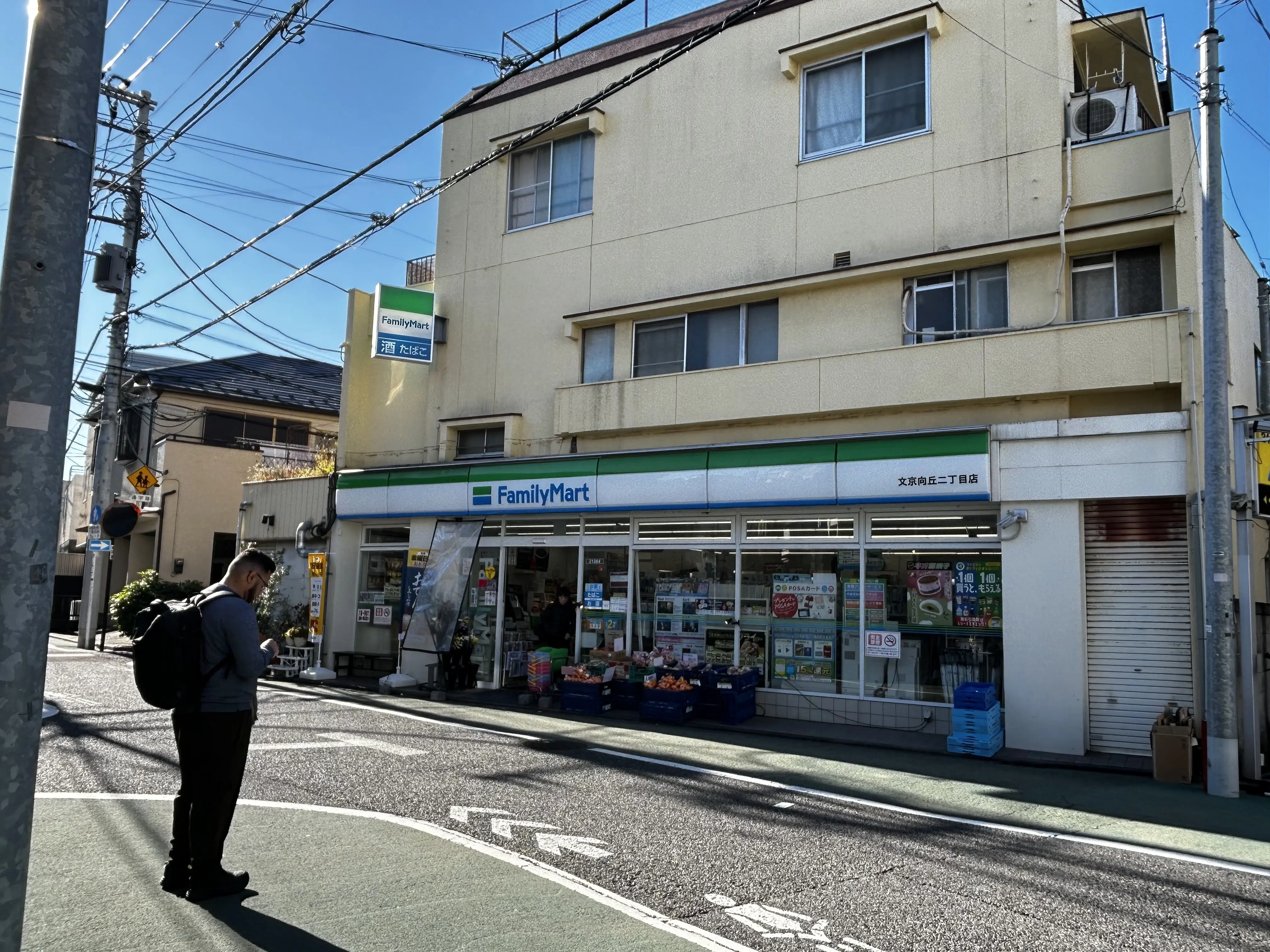 Picture of me looking at my smartphone in front of a Family Mart store