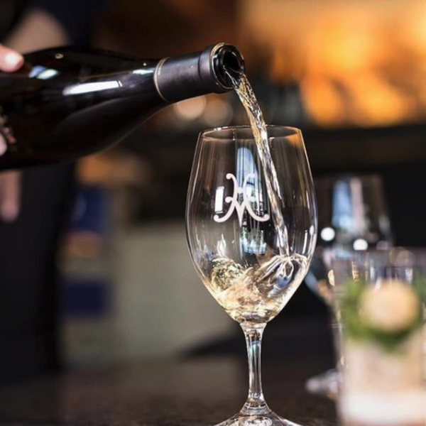 Pouring a glass of white wine at the tasting salon.