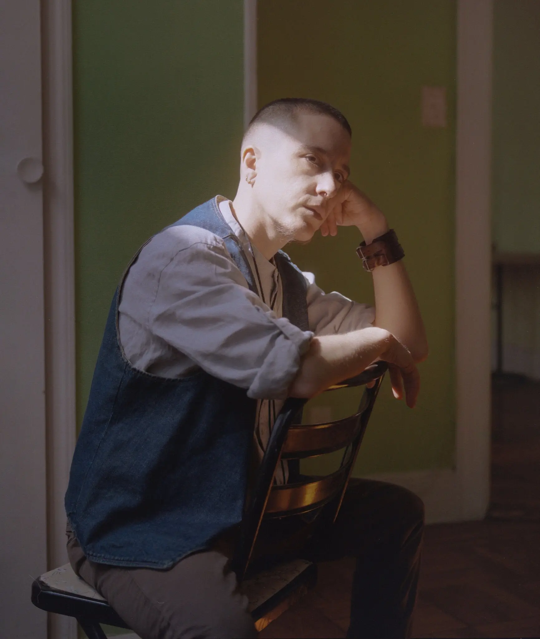 devynn emory from NYT article March 25 2021_shows emory wearing gray top and vest with head resting on hand.jpg
