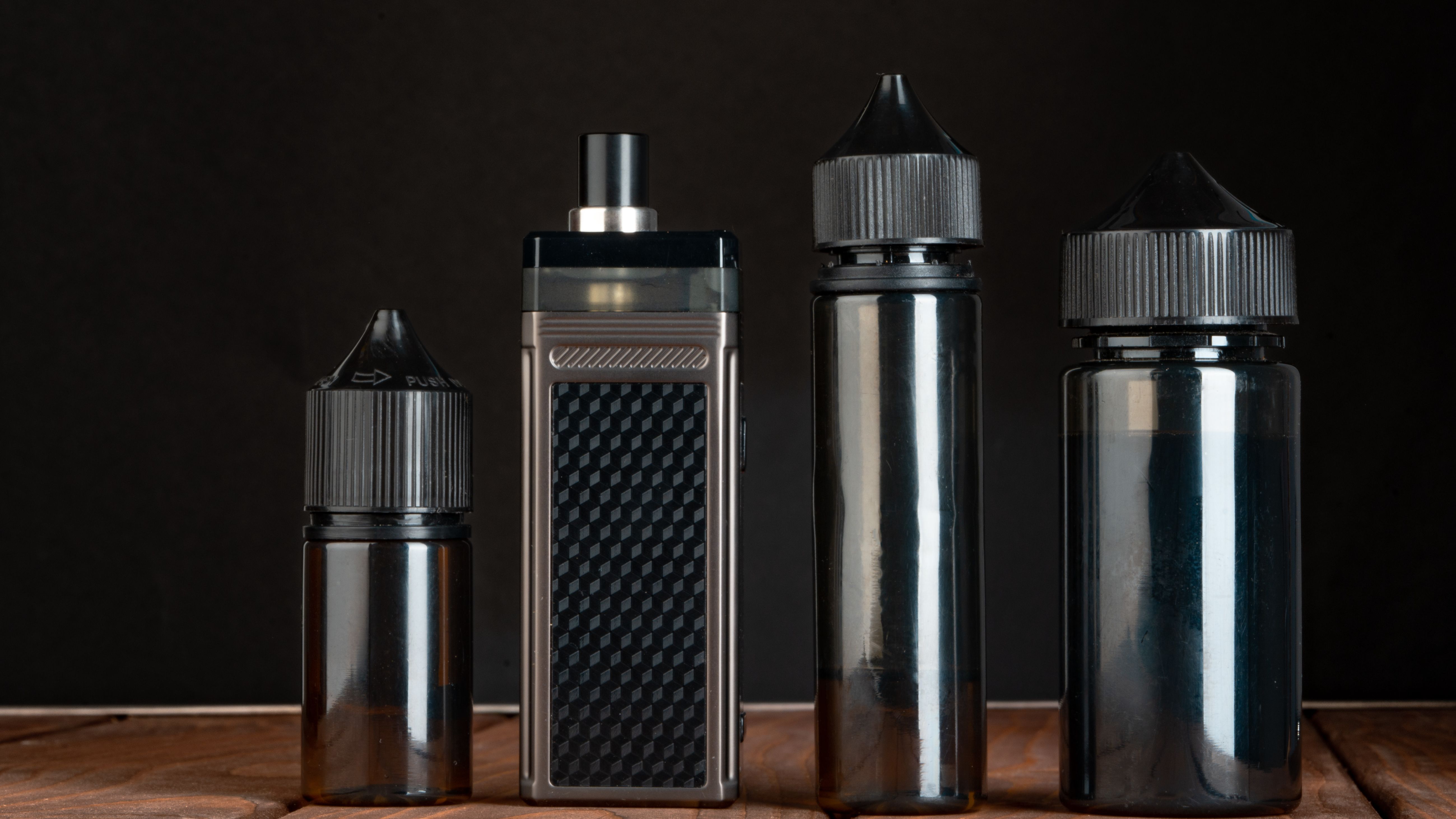 vape-and-vape-liquid-bottles-against-black-backgro-2025-02-24-18-13-38-utc.jpg
