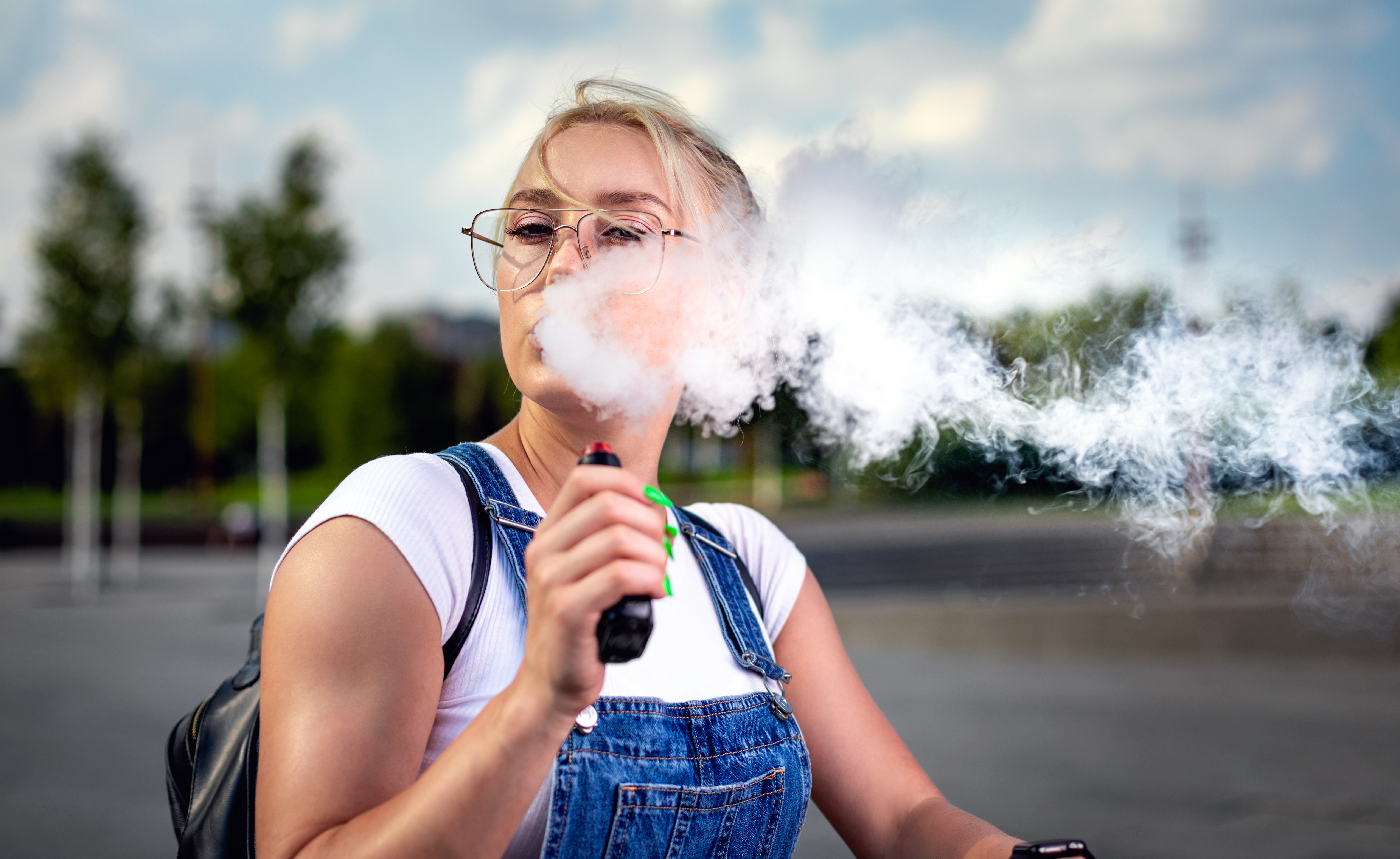 portrait-of-young-woman-smoking-an-e-cigarette-out-2024-10-31-04-23-59-utc.jpg