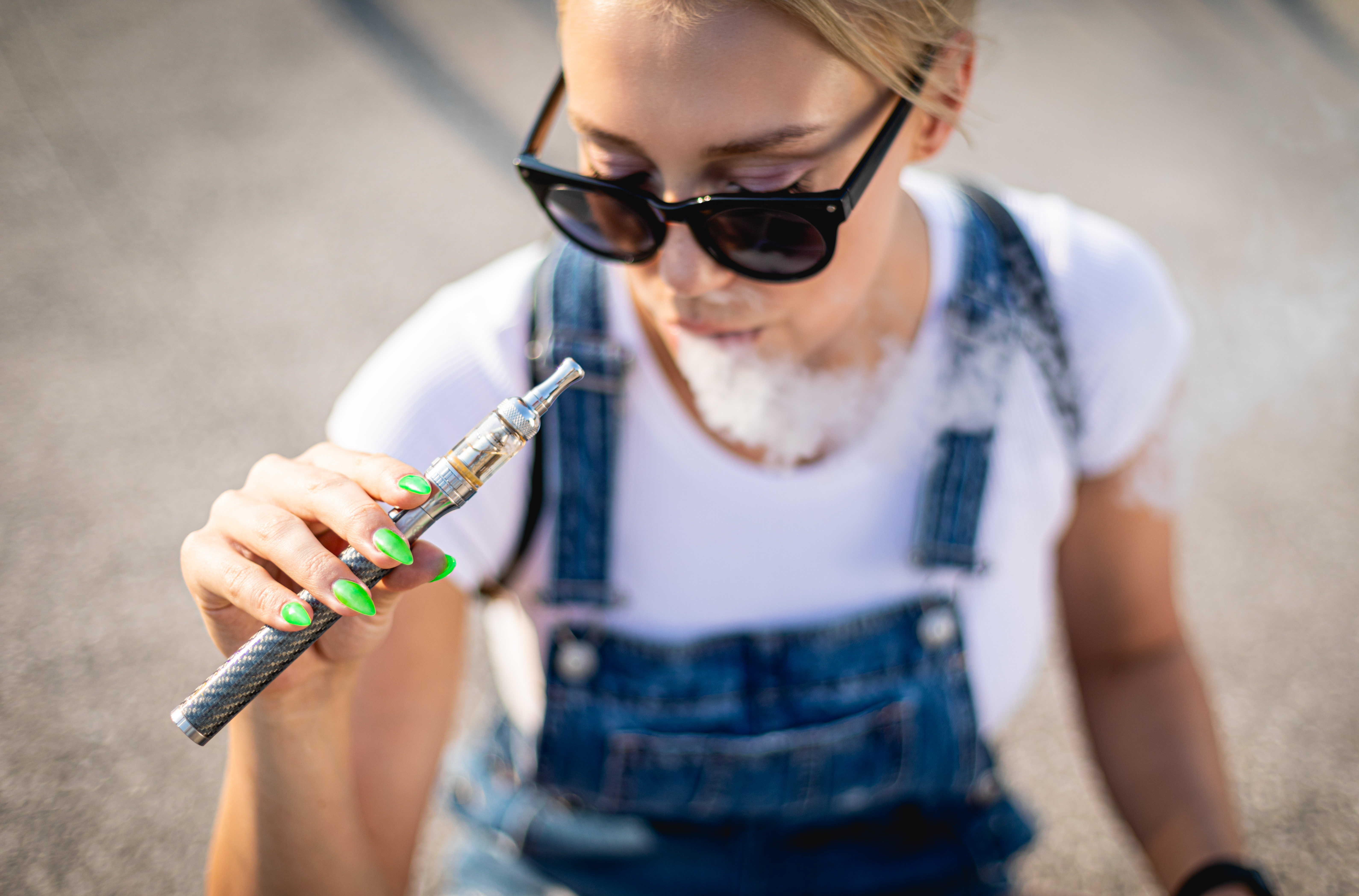 modern-woman-outdoor-smoking-e-cigarette-while-sit-2024-10-31-00-59-14-utc.jpg