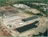 Large manufacturing facility with metal buildings, equipment, and supplies in multiple sections on the property