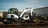 A white Bobcat tractor breaking up asphalt at a job site