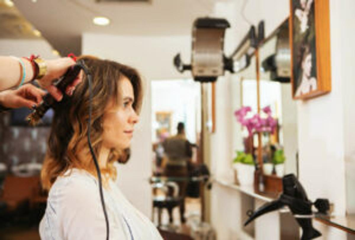female salon client getting hair curled
