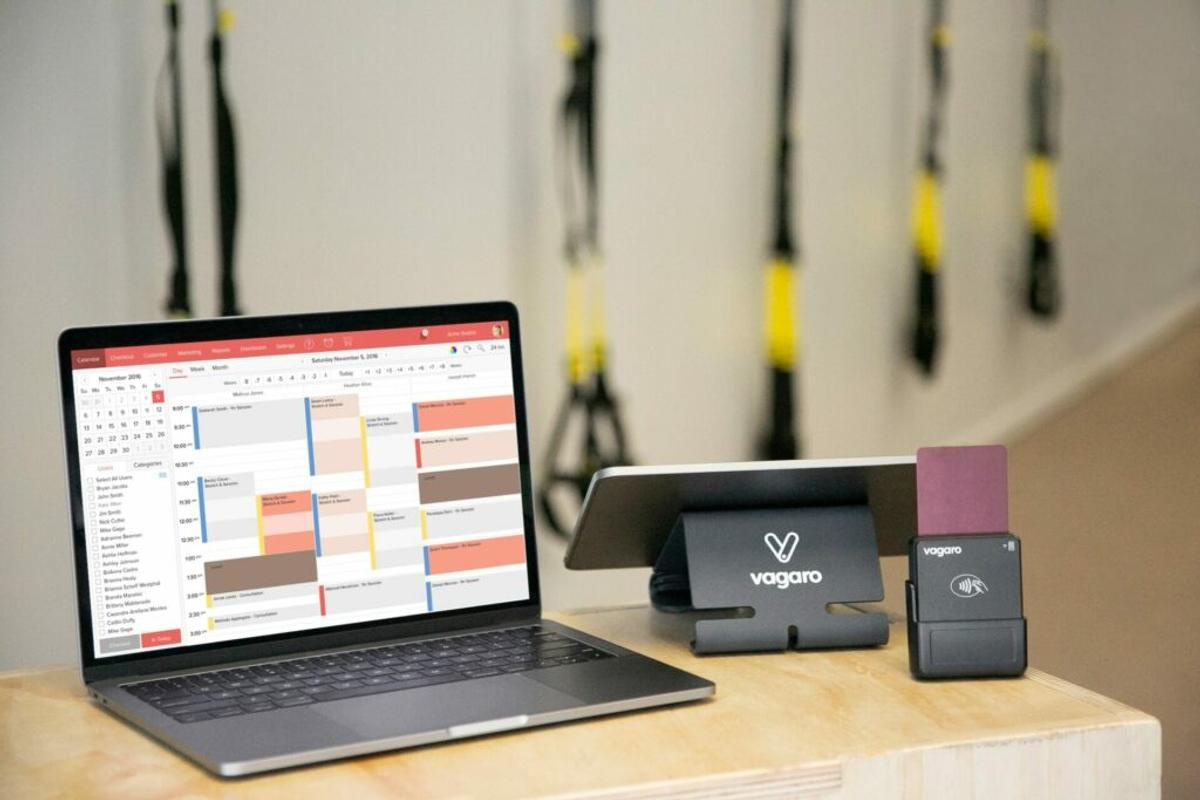 Vagaro gym management software on laptop, tablet and wireless card reader