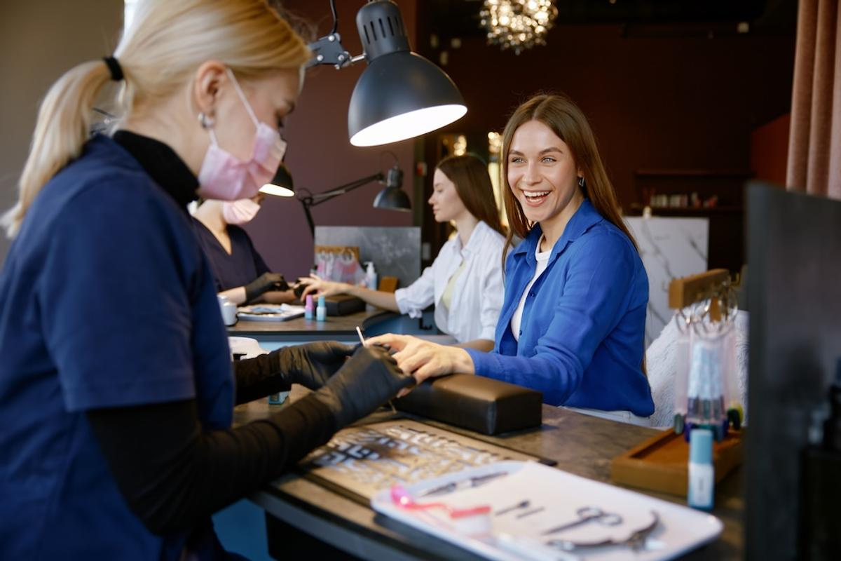 smiling-woman-client-enjoying-manicure-procedure-a-2024-12-05-20-13-19-utc.jpg