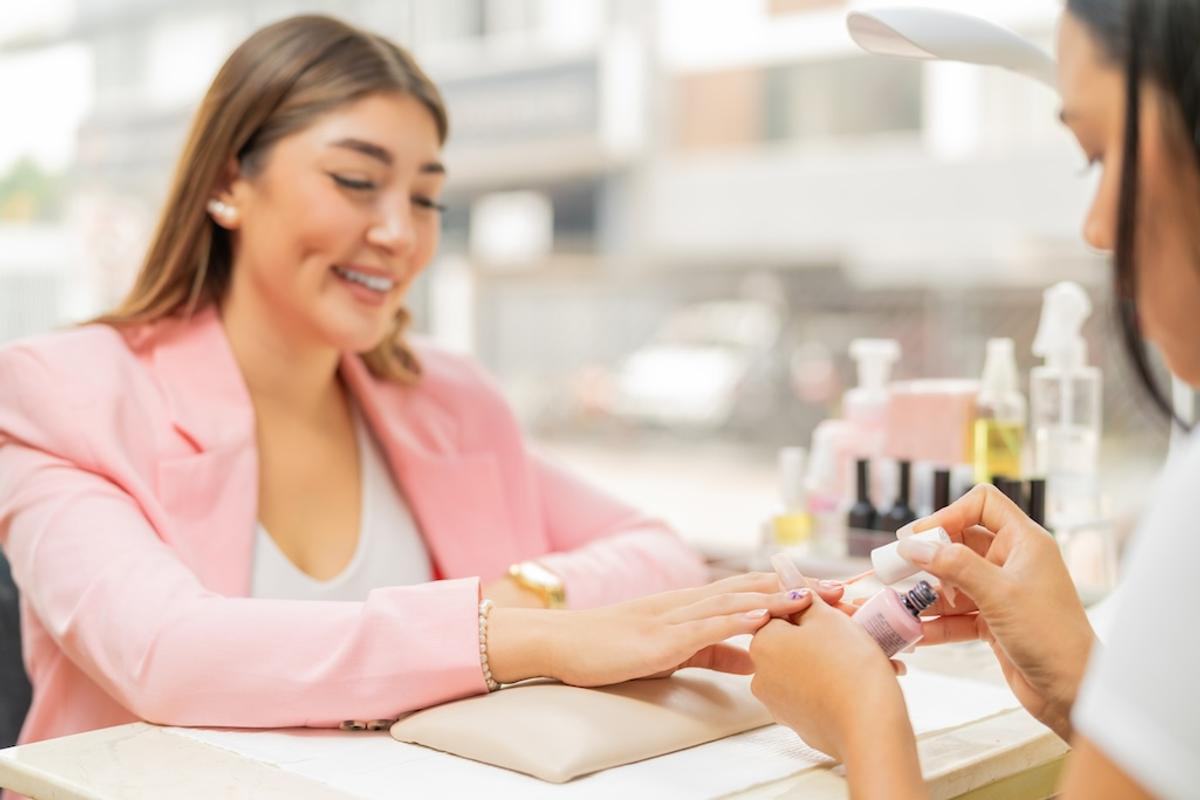 smiling-client-in-a-beauty-salon-painting-her-nail-2025-03-06-00-09-02-utc.jpg