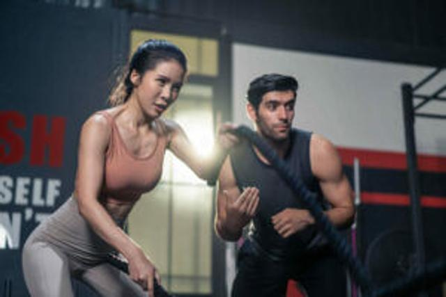 Fit woman working with male personal trainer