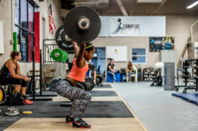 Woman doing snatches At boutique gym