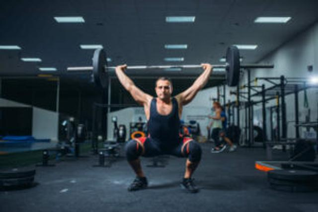Powerlifter doing snatches in powerlifting gym