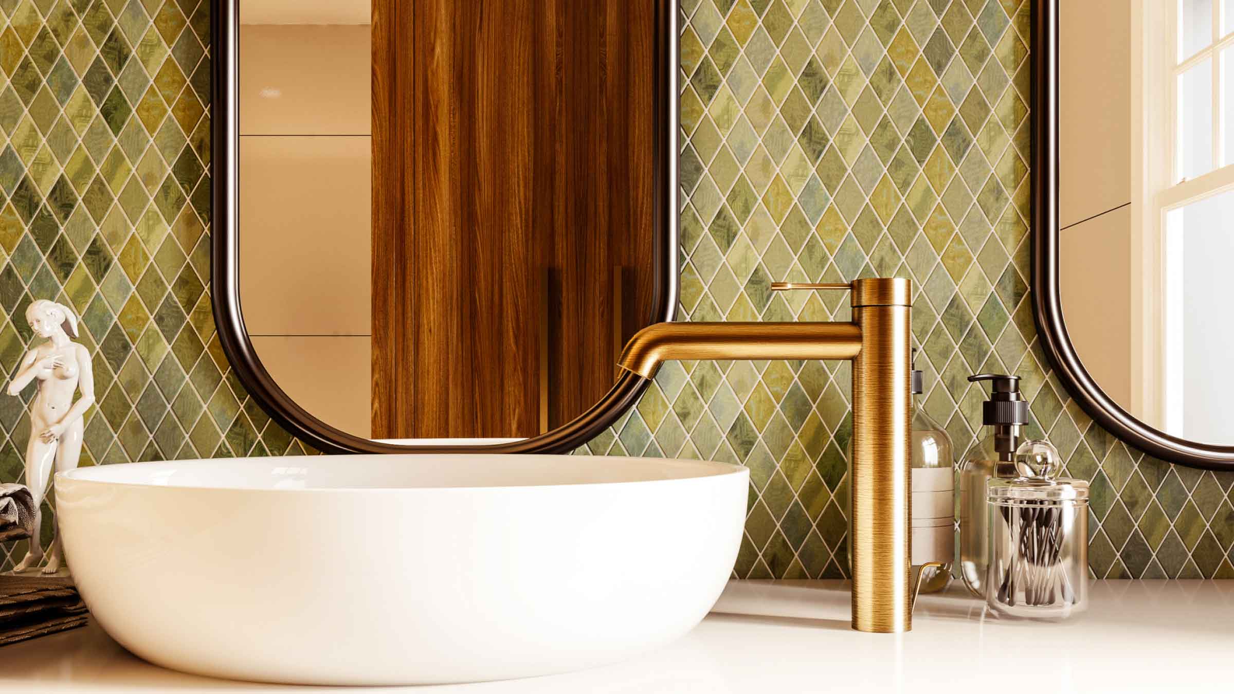 Bathroom with white ceramic raised sink bowl, with one brass tap to the right. Diamond shaped green tiles cover the wall and a modern black framed mirror sits above the sink..