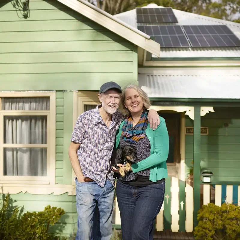 Couple outside home with solar panels