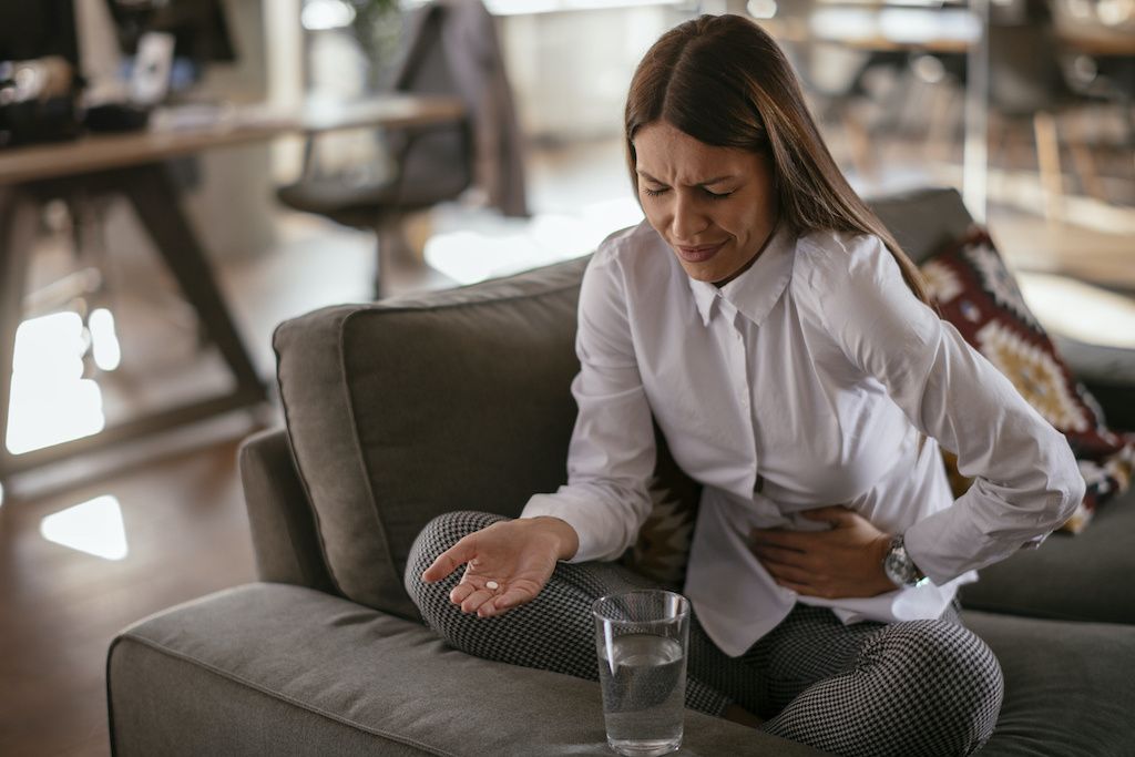  A woman wincing from painful gas