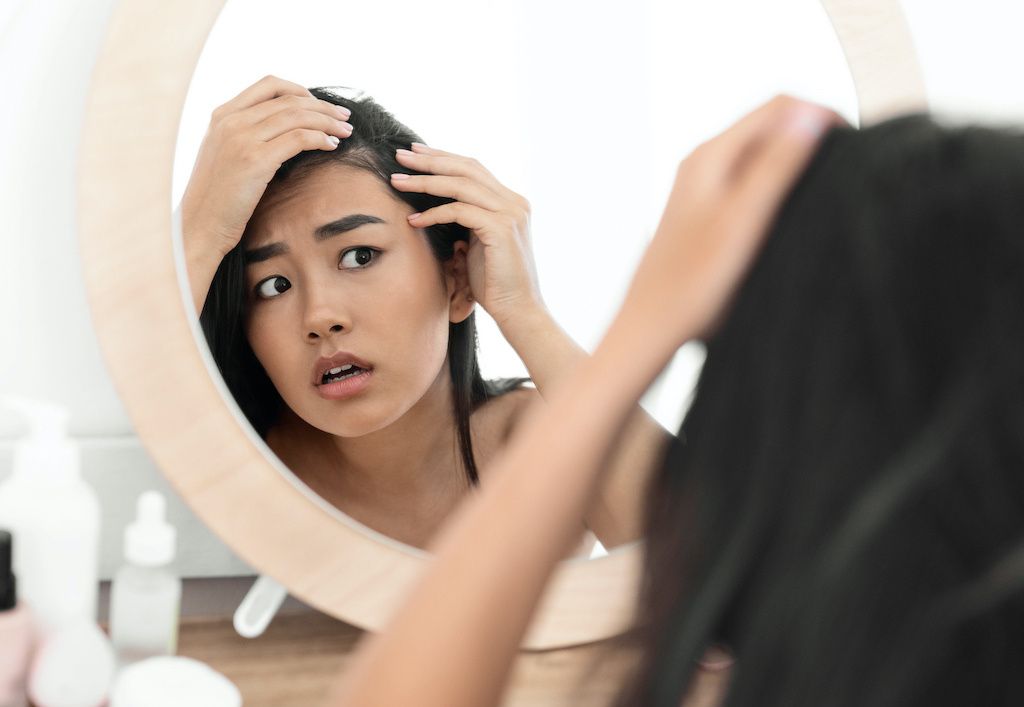 A woman checking her hairline