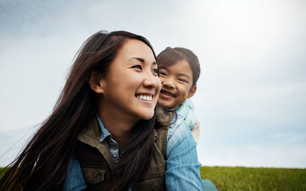 A woman and a child playing outside and looking happy