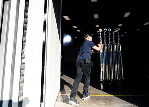 Production worker loading equipment on a television set