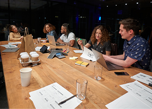 Production workers in a conference room discussing production incentives