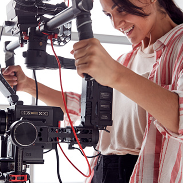 Dark-haired woman operates a steadycam on set 