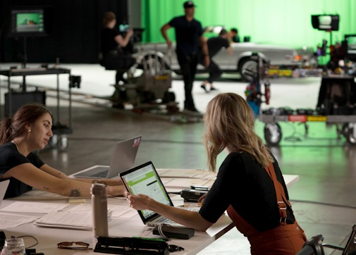 Production workers on set using Movie Magic Budgeting software