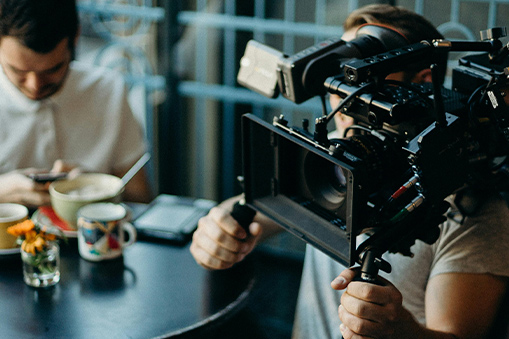 Camera person with cafe table in background