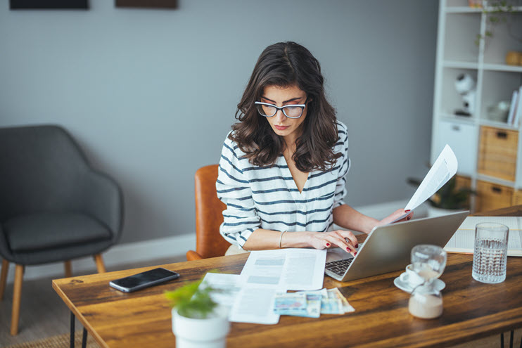 Production accountant reviewing payroll documentation alongside EP film and TV payroll software