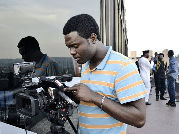 Camera person checking monitor crew in background