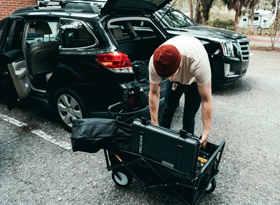 Crew member loading camera cases