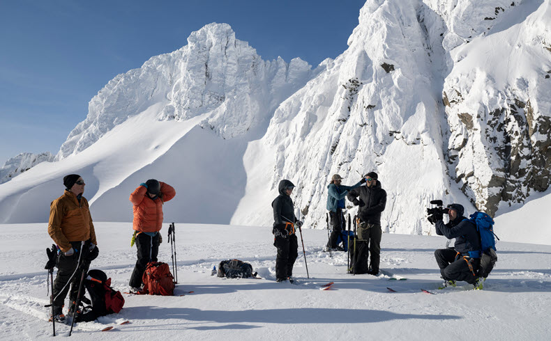 Camera crew on skies shooting in remote snowy location