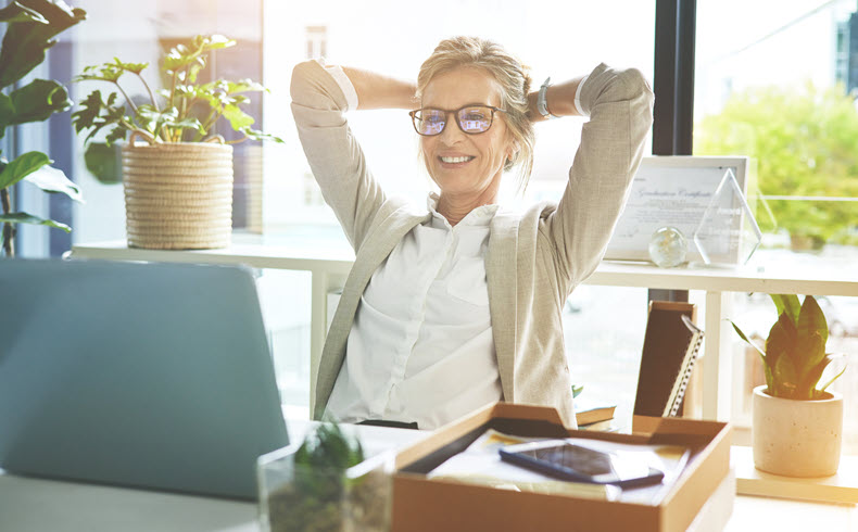 Businessperson smiling at open laptop with relaxed expression