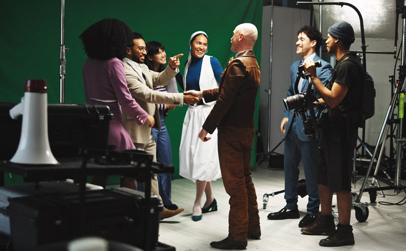 Crew and Cast meeting on set in front of green screen backdrop