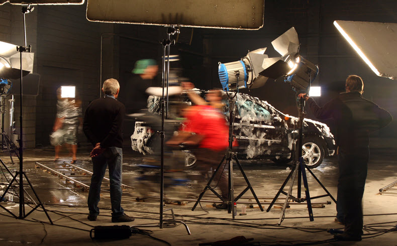 Behind the scenes set car with soap suds and blurred crew movement