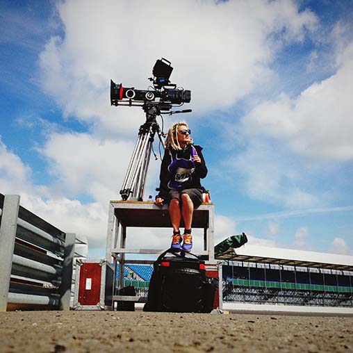 Female camera operator sitting outdoors