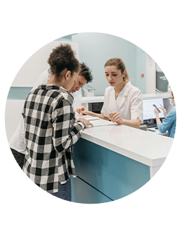 Couple at healthcare office signing paperwork at front desk with nurse