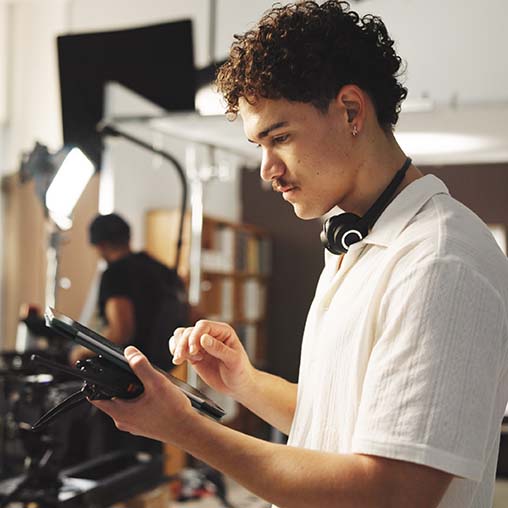 Young man looking at a digital tablet on a film set