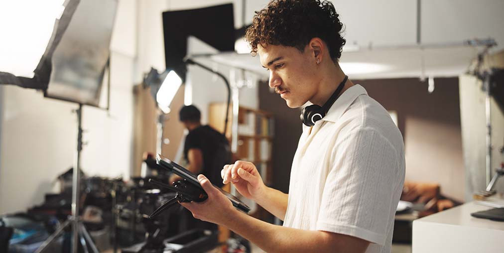 young man on a film set-production lot celebrates ten thousand members from across the film community