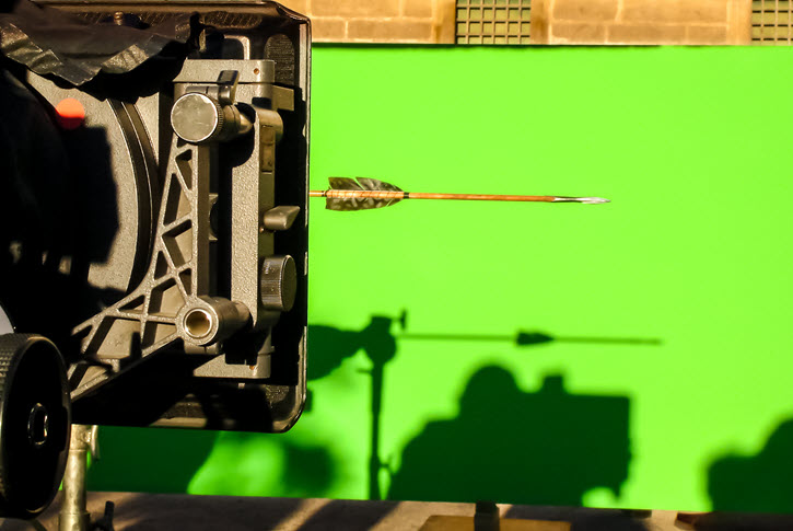 Camera equipment filming mounted arrow in front of green screen