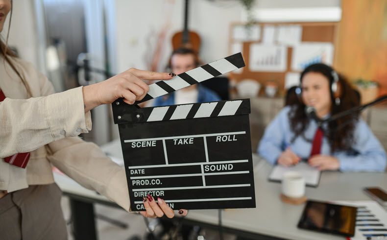 Clapperboard marking a scene take during a podcast and video production recording session.