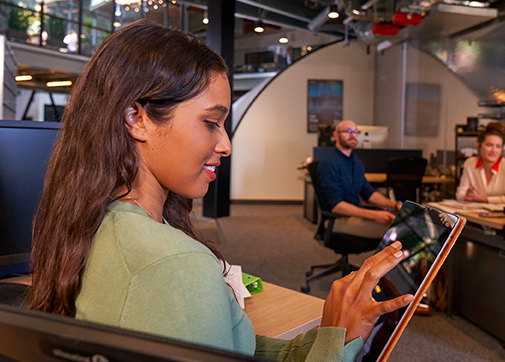 Woman in office working on mobile tablet.