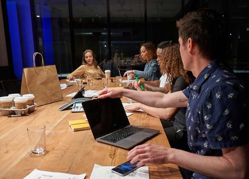 movie production crew working on digital budget and crew scheduling solution at conference table