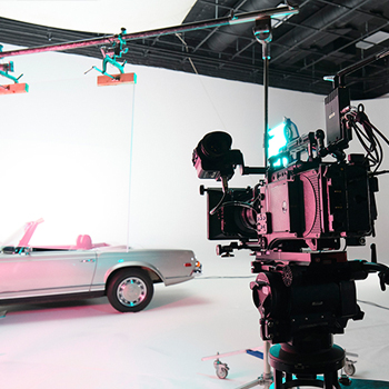 car in front of film production camera on set