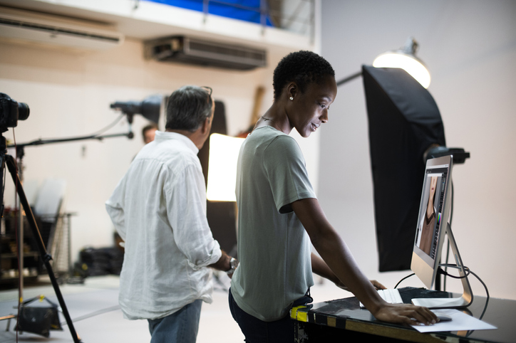 Director or editor on set during shoot looking at computer screen