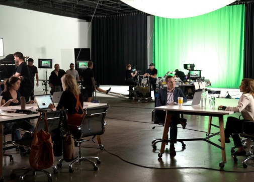 Production workers on set with green screen in the back working with the Scenechronize digital software solution