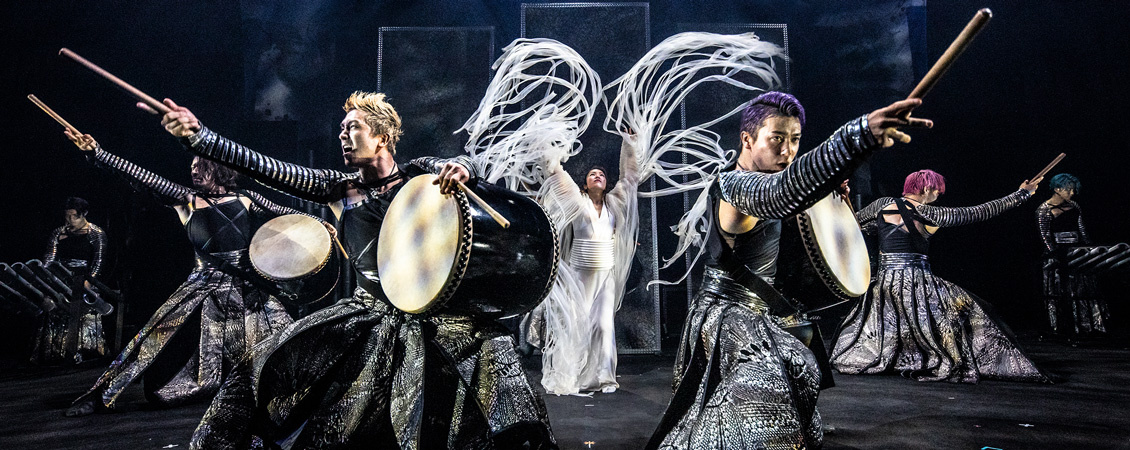 Japanese drum and dance ensemble performing on stage. 