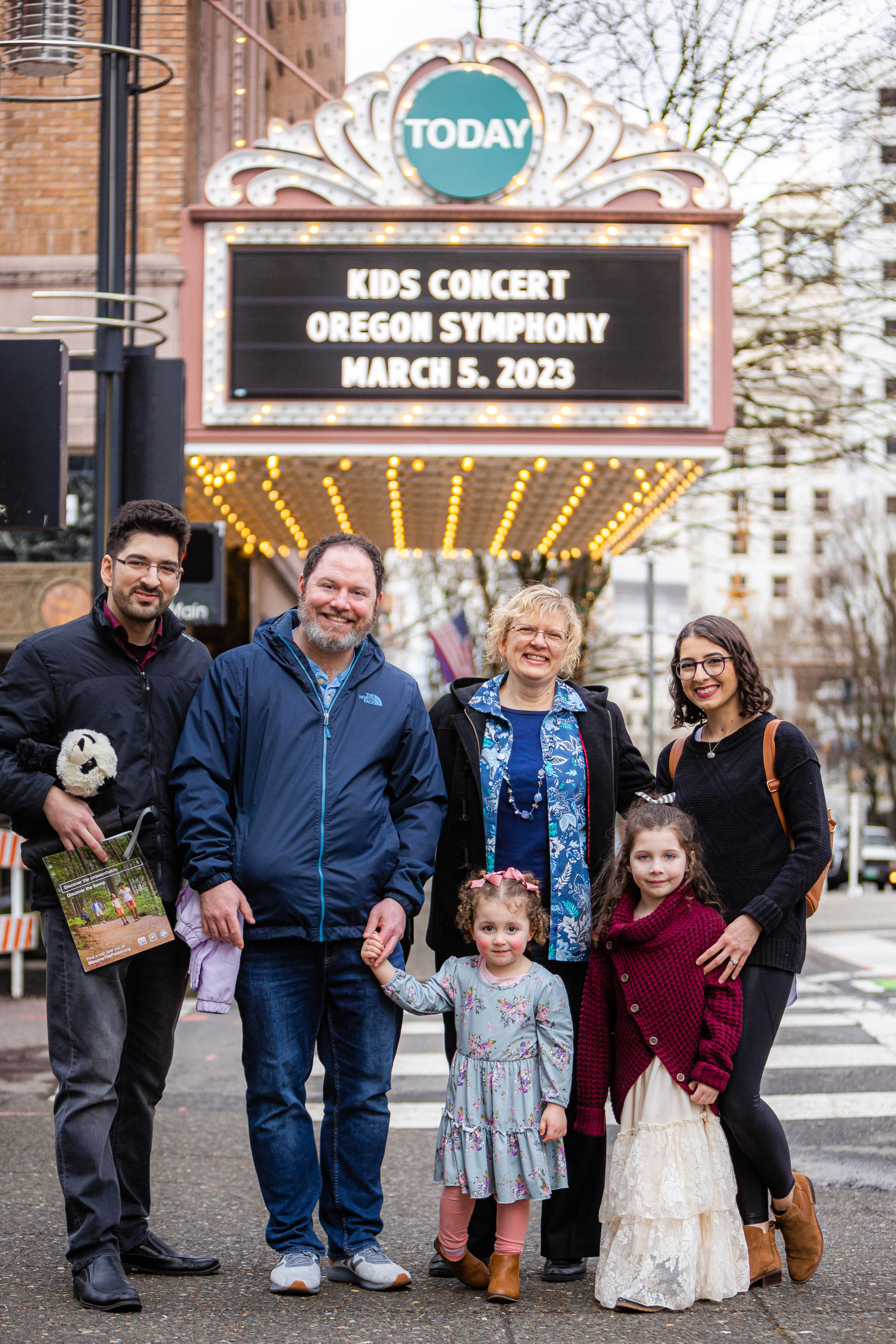 A family stands for a picture out from the Arlene Schnitzer Concert Hall.