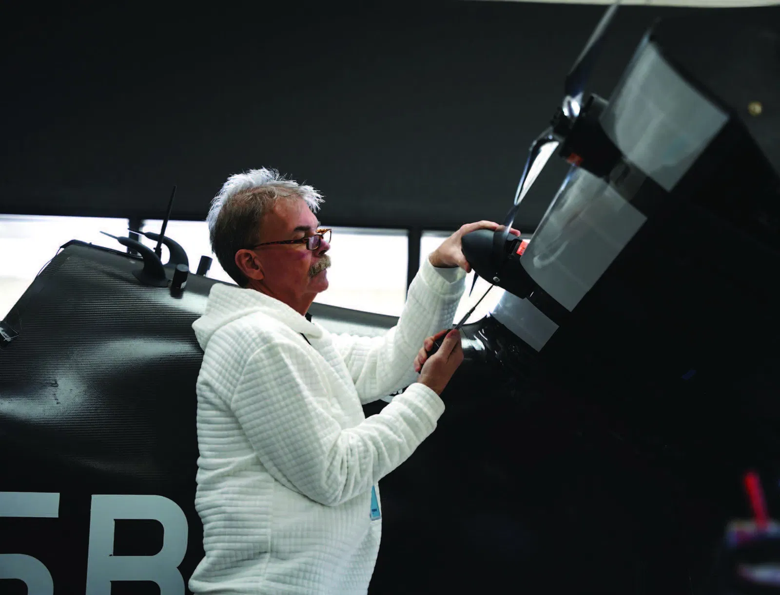 Pivotal pilot Dean Owen practices using screwdriver to put spinners on BlackFly aircraft propellor.