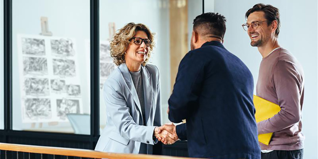 A woman shaking hands with production clients
