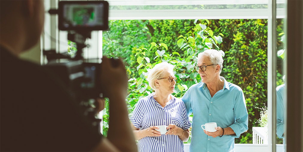 A senior couple in front of a camera