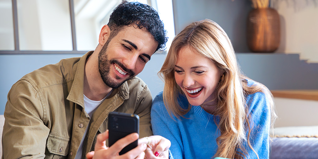 A man and woman looking at a cell phone