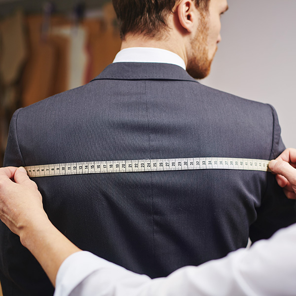 A man getting a his coat measurements taken